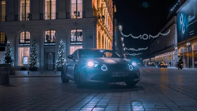 A car is parked in front of a building at night