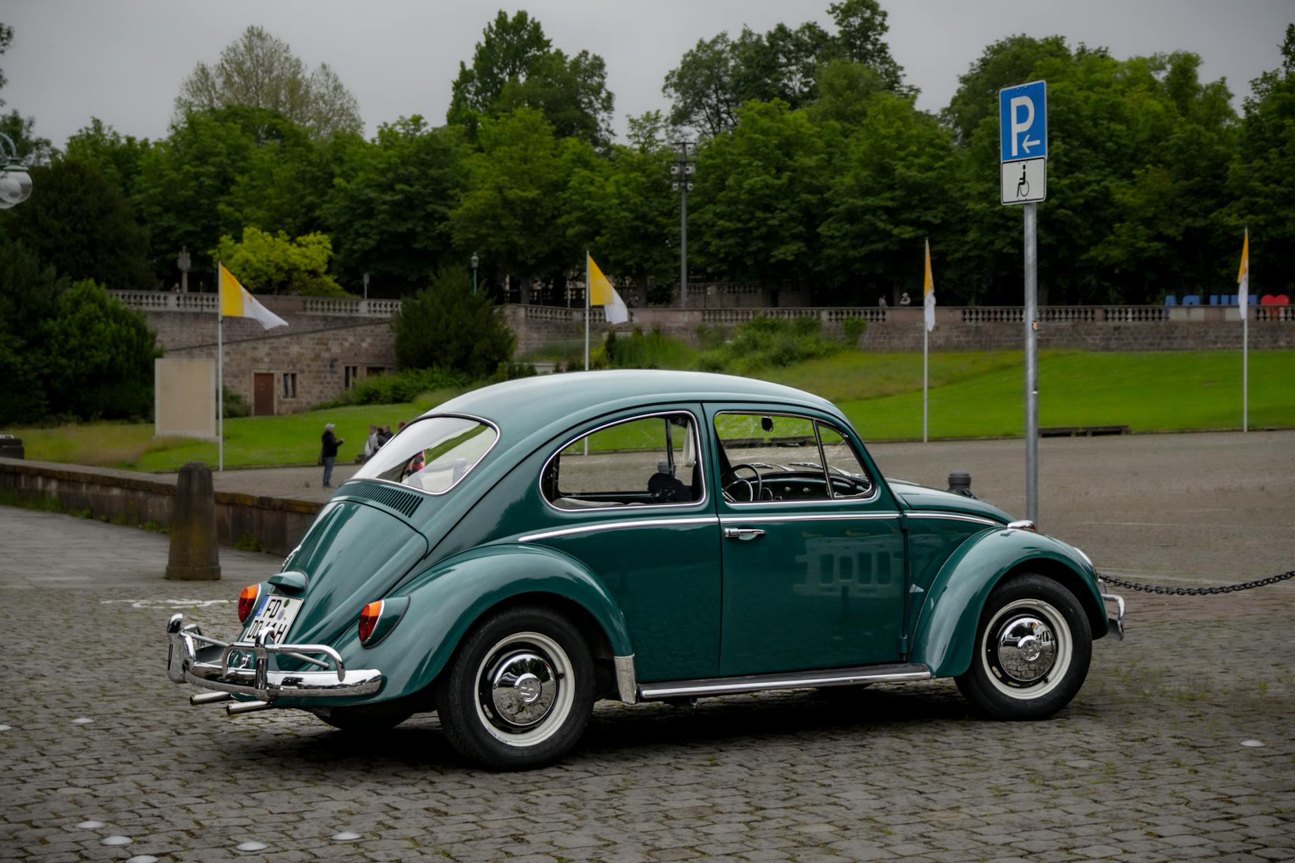 a green volkswagen beetle parked on a paved road